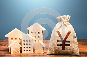 Houses and chinese yuan or japanese yen money bag. Energy efficiency and costs for heating and home services. Community municipal