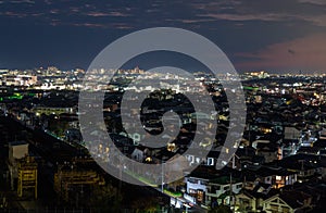 Houses in dark residential neighborhood near city at night