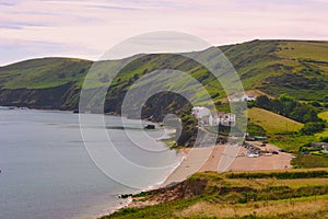 Houses on the easide with cliffs close to the lighthouse of Start Point, Devon, England