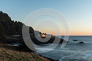 Houses on the edge of a cliff at sunset in a cove of the Pacific Ocean on the coast of Oregon, USA.