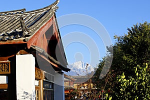 Houses in the historic village of Baisha with the mountains in the background, Lijiang, Yunnan, China