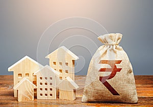 Houses and indian rupee money bag. Community municipal budget. Overheated market. Energy efficiency and costs for heating and home
