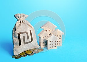 Houses and israeli shekel money bag. Increasing property value. Fair market price. Home taxation. Residential or commercial