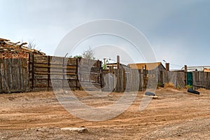 Houses in kalmyk village with a high wooden fence