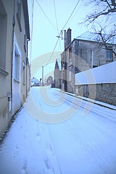 Houses line a picturesque narrow street in Saint-Loup-de-Naud