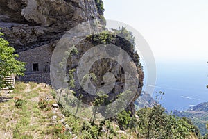 Houses made in the rock wall and the farms photo