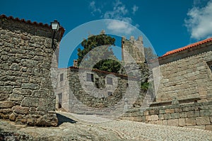 Houses made of stone with alley on slope and tower