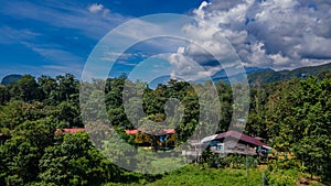 Houses at the Mulu village surrounded by tropical forest and mountains near Gunung Mulu national park. Borneo. Sarawak.