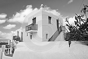 Houses in Mykonos, Greece. Whitewashed buildings with blue painted windows and doors on sunny sky. Typical architecture