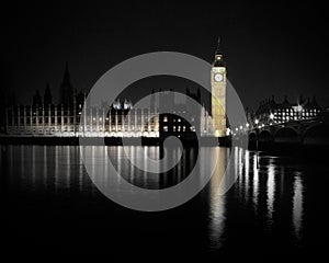 Houses of parliament at night with reflection in water.