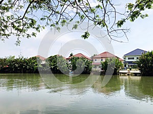 Houses at riverfront against sky