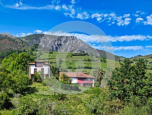 Houses at Sardera village and Sierra del Sueve in background, Asturias, Spain photo