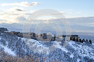 Houses on snowy mountain overlooking Wasatch Mountains and residential valley