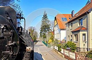 Houses in the streets of the city of Wernigerode with a passing steam locomotive. Dynamic through motion blur