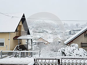 Houses and trees and fences under white snow - village Milanovac at winter, Croatia