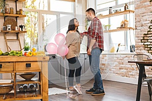 Housewarming couple. Young couple holding wine glasses in kitchen at home. Celebrating a holiday concept