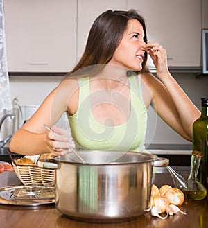 Housewife with bad smelling pan