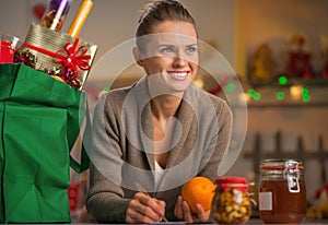 Housewife with christmas shopping bag in kitchen