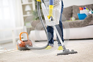 Housewife clean carpet with vacuum cleaner