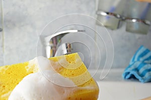 Housewife cleaning bathroom tap and shower Tap. Maid in yellow protective gloves washing dirty bath tap. Hands of woman washing or