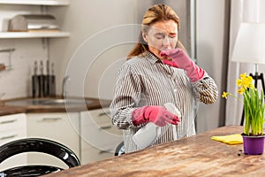 Housewife cleaning the kitchen sneezing while having allergy