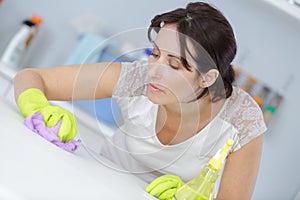 Housewife cleaning surface table with disinfectant