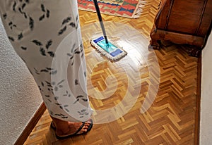 Housewife cleaning the wooden floor