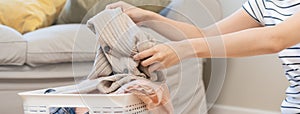 Housewife, close up hand in asian young woman take out the washing clean clothes from the basket to fold it in after it has dried