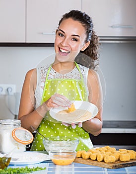 Housewife cooking breadcrumbed croquettes