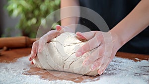 Housewife cooking homemade dough for bread or pie, closeup view of woman hands on kitchen table