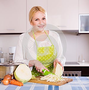 Housewife cooking shredded sauerkraut indoors