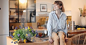 Housewife decorating interior with flowers in the kitchen