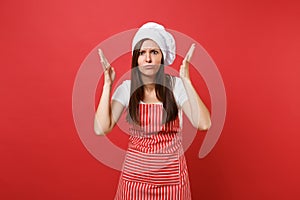 Housewife female chef cook or baker in striped apron, white t-shirt, toque chefs hat isolated on red wall background