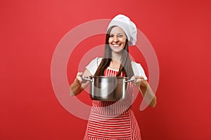 Housewife female chef cook or baker in striped apron white t-shirt toque chefs hat isolated on red wall background