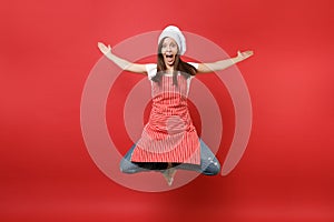 Housewife female chef cook or baker in striped apron white t-shirt, toque chefs hat isolated on red wall background