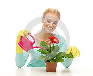 Housewife with flower in pot and watering can