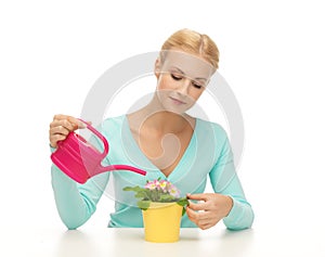 Housewife with flower in pot and watering can