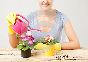 Housewife with flower in pot and watering can