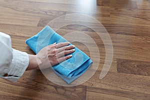 Housewife hand cleaning laminated wooden floor