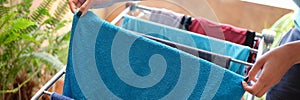 Housewife hanging clothes on dryer at home closeup