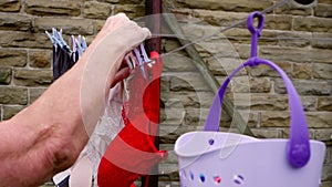 Housewife hangs laundry out on washing line to dry