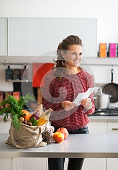 Housewife holding grocery shopping checks