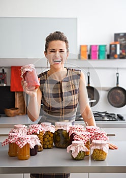 Housewife among jars with homemade fruits jam