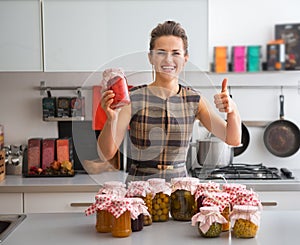 Housewife among jars with homemade fruits jam