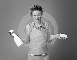 Housewife with kitchen sponge and bottle of detergent on