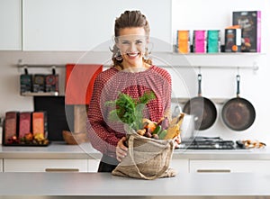 Housewife with local market purchases in kitchen