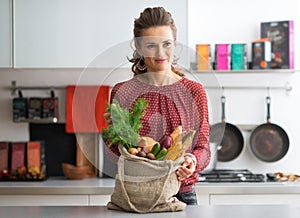 Housewife with local market purchases in kitchen