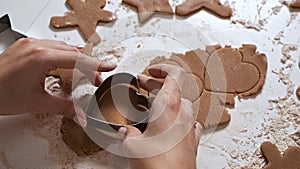 Housewife makes christmas cookies. Woman made a shape of gingerbread in the form of hearts from raw dough