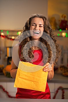 Housewife opening envelope in decorated kitchen