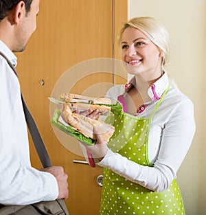 Housewife preparing sandwich for husband